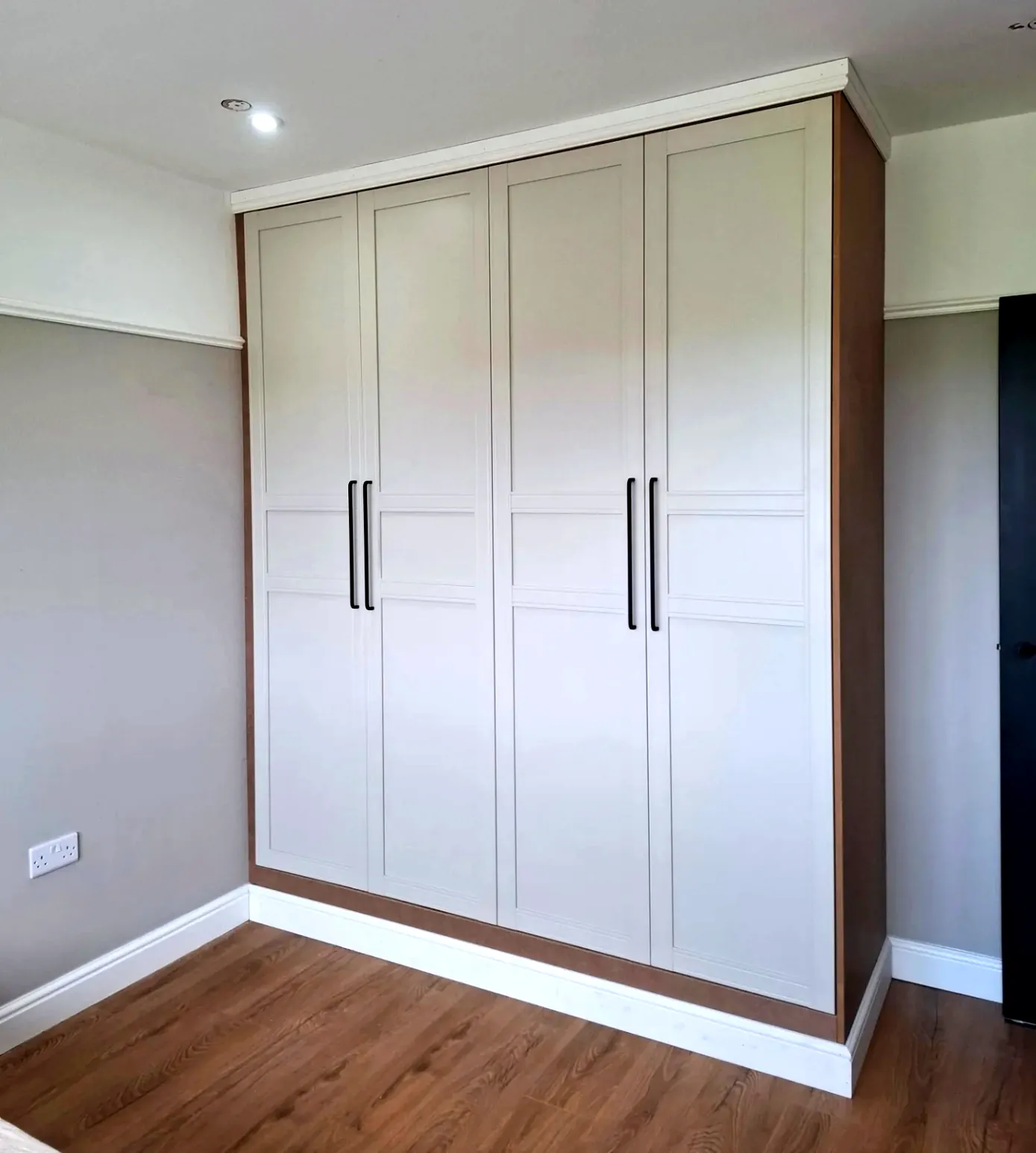 Four-door shaker wardrobe built in to the ceiling with cornice and skirting