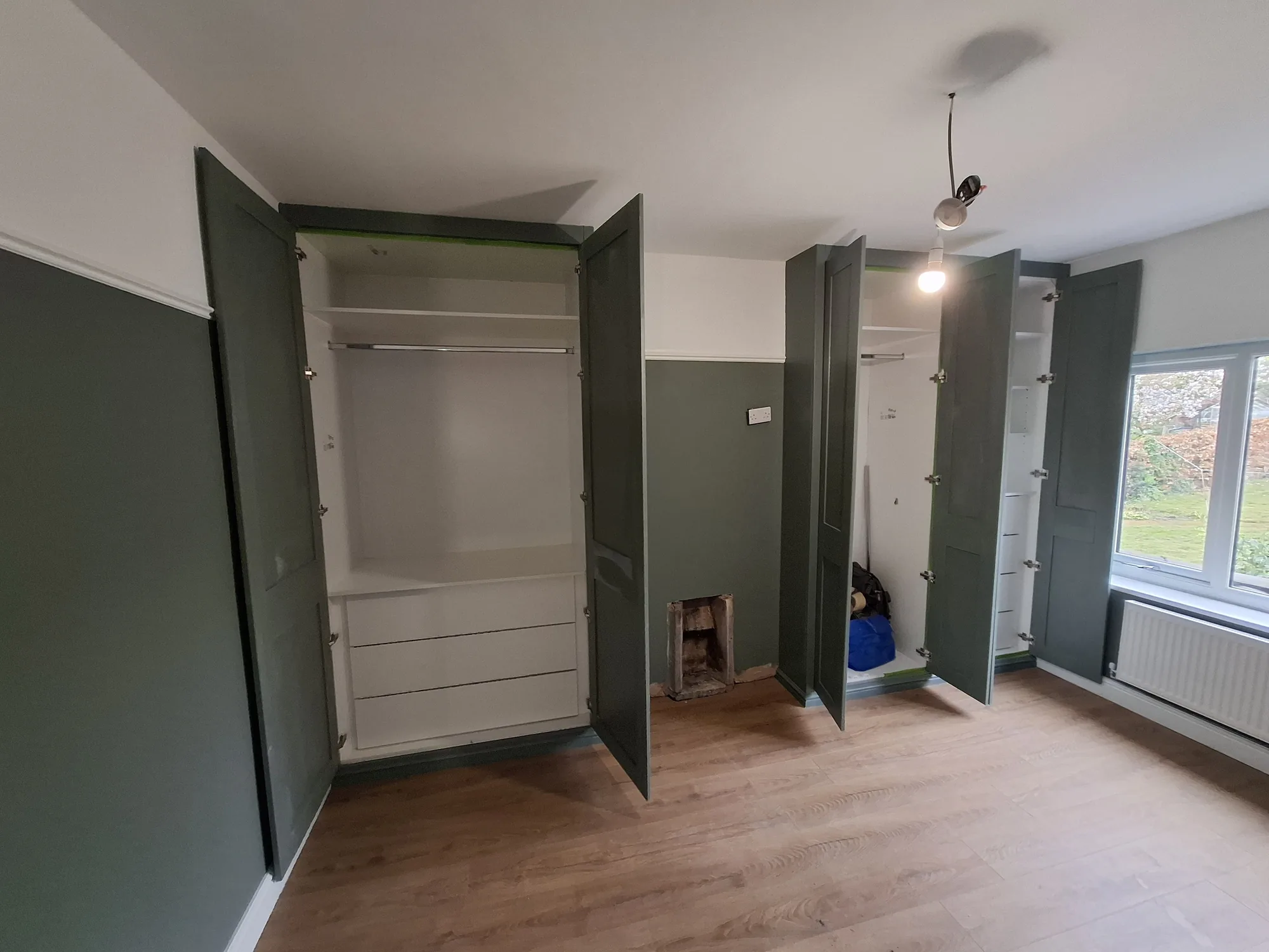 Wardrobe doors open showing rails, shelves and drawers
