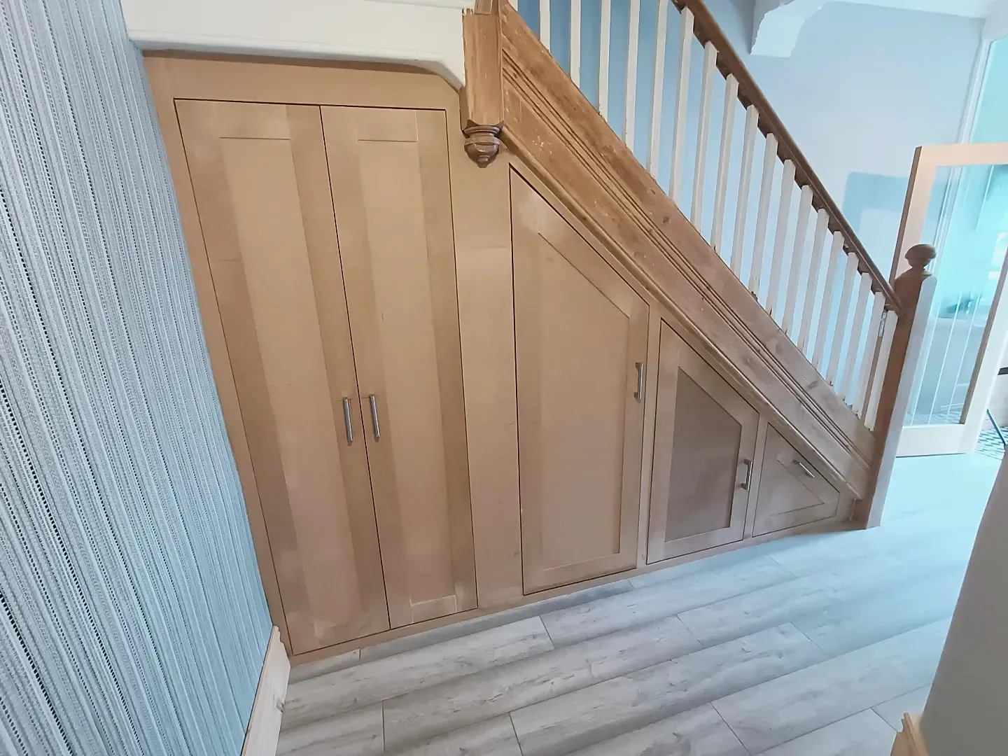Under-stairs storage with shaker doors following the stair line