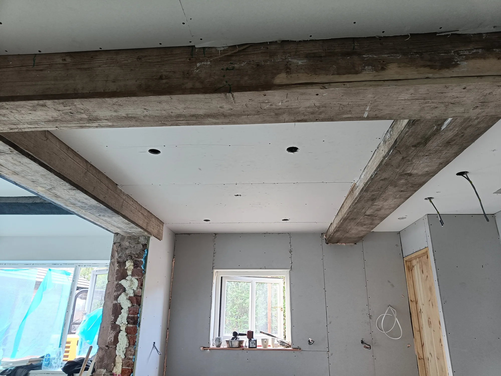 Steel beams wrapped in rustic timber across a ceiling